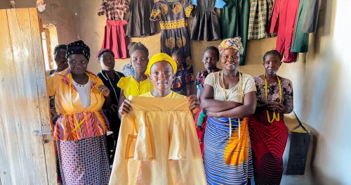 Group of Zambian women show off clothes they've sewn.