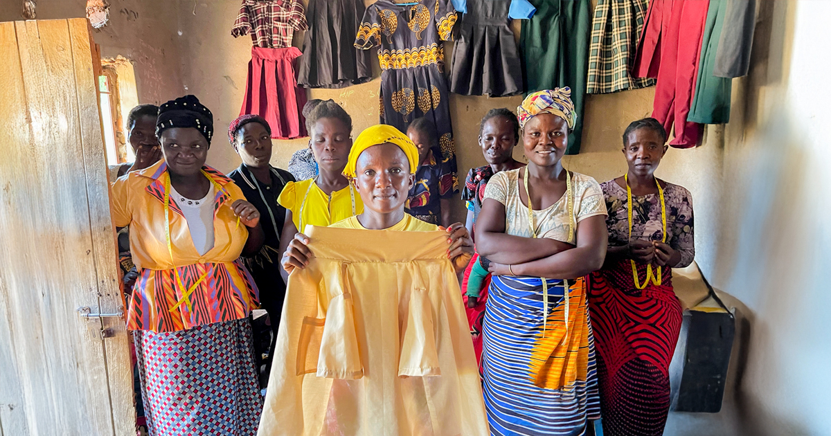 Women show off clothes they've sewn.