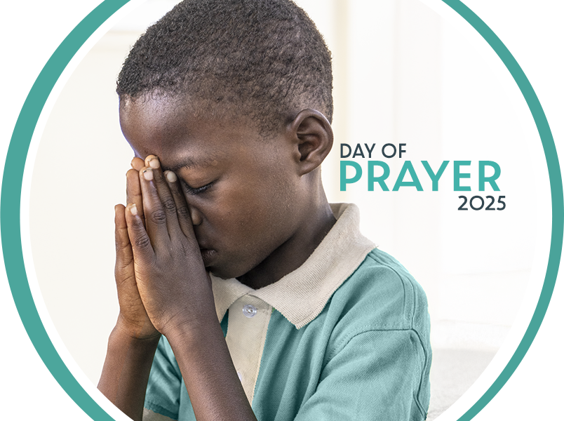 Day of Prayer 2025 Photo: Boy living in the Batey Comoquiera, Dominican Republic, in school uniform, praying with his eyes closed.