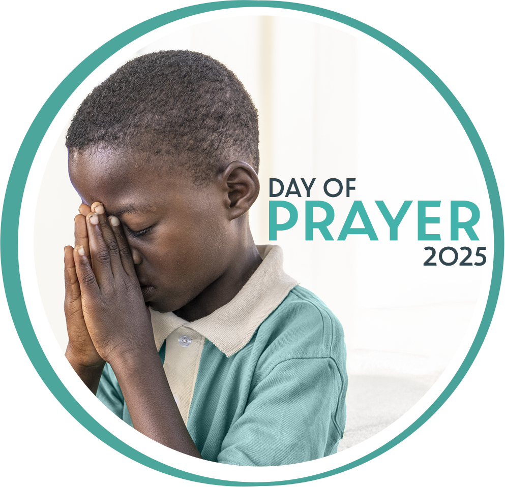 Day of Prayer 2025 Photo: Boy living in the Batey Comoquiera, Dominican Republic, in school uniform, praying with his eyes closed.