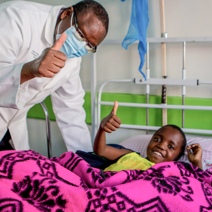 Boy receiving medical care and doctor smiling to the camera in Malawi