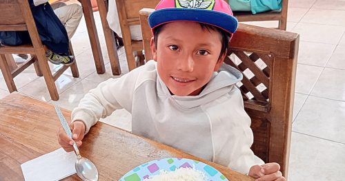 Bryan, a little boy, sits at a table with a healthy meal before him.